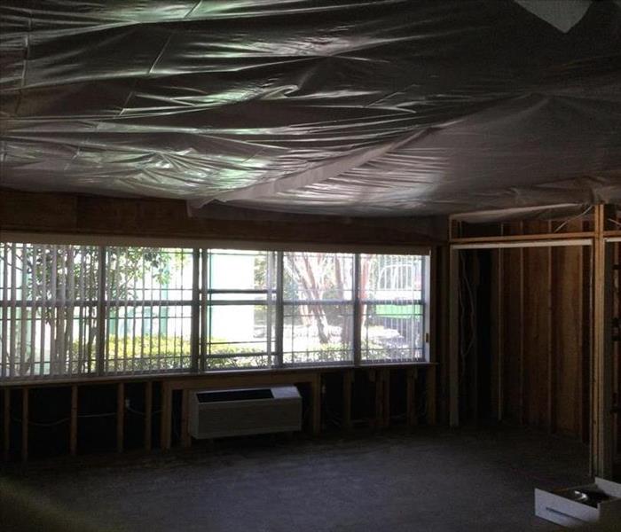 den room with exposed framing and no insulation with plastic containment on ceiling 