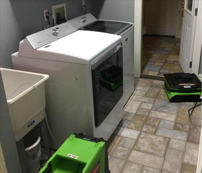 green fan and dehumidifier in laundry room 